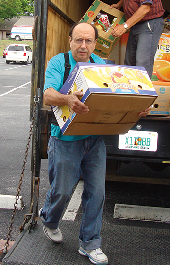Jim Wojcik unloads groceries for the church food pantry